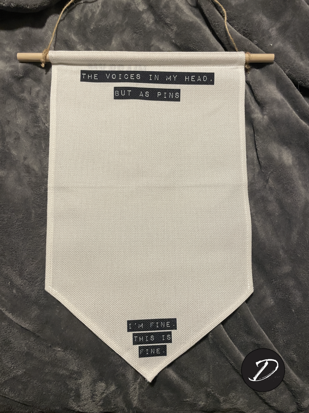 Hanging wall banner for pins with retro label-maker style text blocks. Top text reads "The Voices In My Head, But As Pins." Bottom text reads "I'm Fine. This Is Fine."