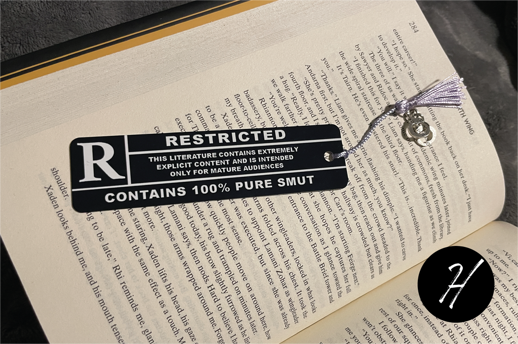 Book with a humorous 'Restricted' tag labeled '100% Pure Smut' on an open book.