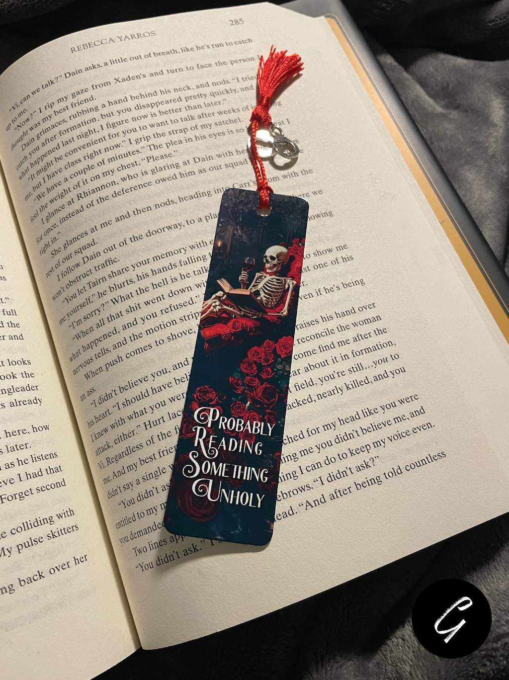 Book with a decorative smut bookmark featuring a skeleton and roses on an open book