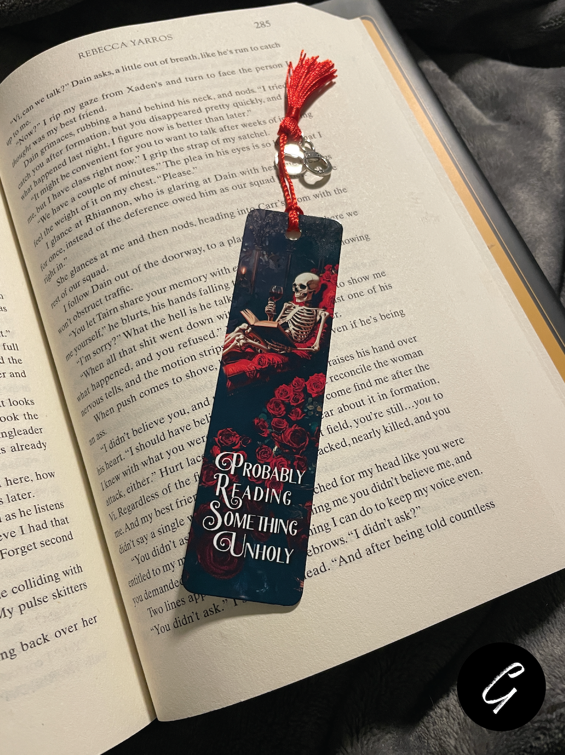 Book with a decorative smut bookmark featuring a skeleton and roses on an open book